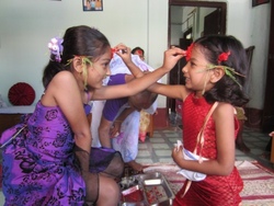 Two sisters putting tika on each other's forehead. Usually it is the elder sister who puts tika on her younger sister's forehead as a blessing.